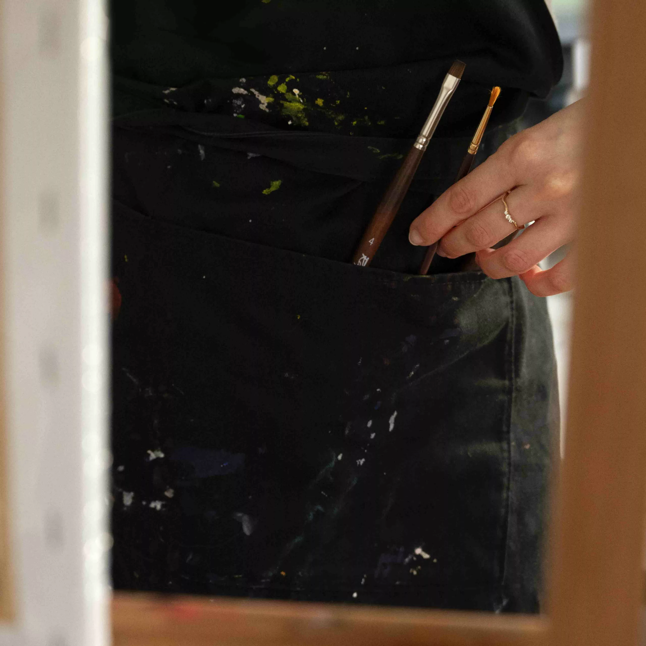 Close-up on the apron of Enolie, a French artist and painter, that she uses to paint and create art.